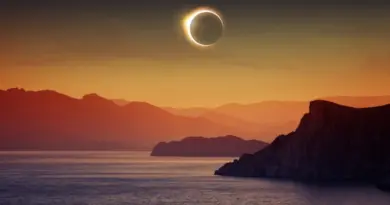 A photo illustration of a total eclipse above a scenic, rural, water-based tourism destination in Europe.